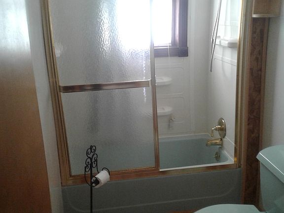 Bath tub with sliding glass door.