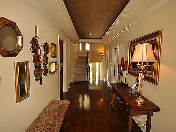 Beautiful entry way with pop out ceiling, crown molding and gorgeous wood floors.