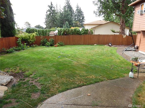 Large fenced back yard with garden and play area.