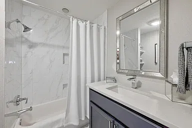 Guest bedroom has private bathroom with tub and shower combination.