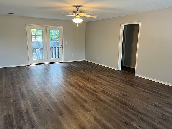 Living and dining room with french doors leading to the private backyard