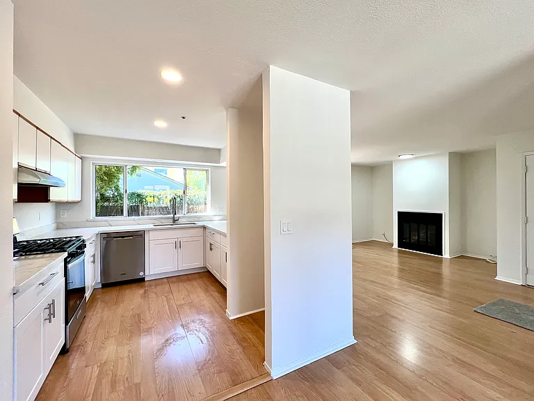 Open floor plan with kitchen and living room. Refrigerator (not shown) is provided.