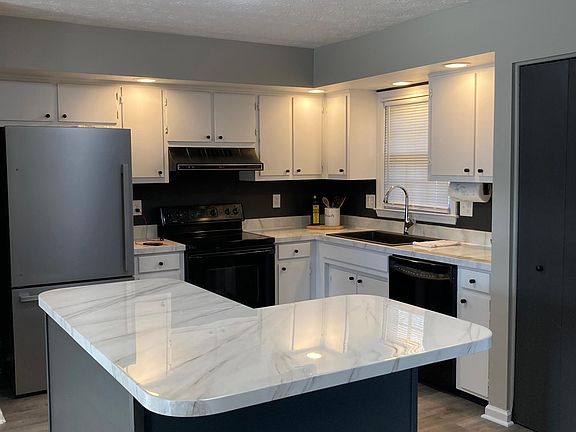 Updated kitchen includes a beautiful island, new refrigerator and farmhouse sink with new faucet. A built in pantry, stove and dishwasher round out the amenities in this stylish kitchen.