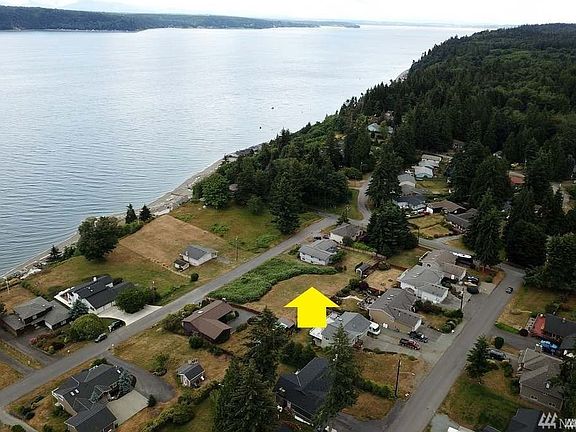 This aerial view shows 2 vacant lots, partially cleared, in the middle of the photo. The subject property is on the South side 