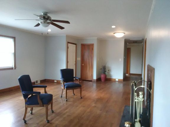 Wood burning fireplace in large family room with natural light from two different walls; ceiling fan/light; beautiful refinished original hardwoods here and and all three bedrooms.
