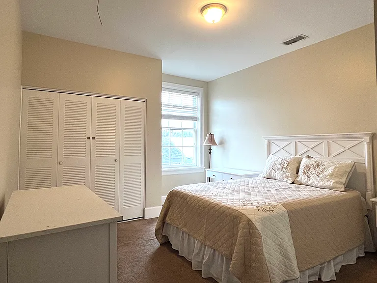 Light fiilled bedroom with queen bed