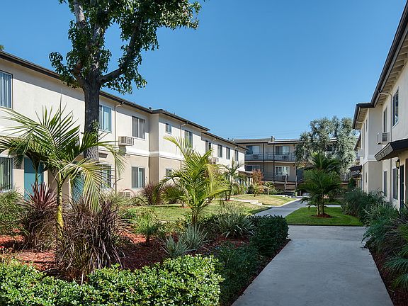 Grassy courtyard with paths leading to apartment homes.