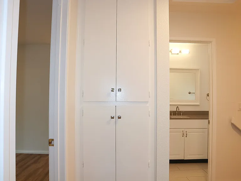 Upstairs hall storage cabinets with the Primary Room entrance door to the left and the hall bathroom to the right.