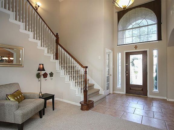 Elegant transom window above the wood and glass entry door with sidelights. Door to the right is the study.