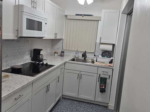 New kitchen cabinets, sink, garbage disposal, microwave and refrigerator with ice maker.