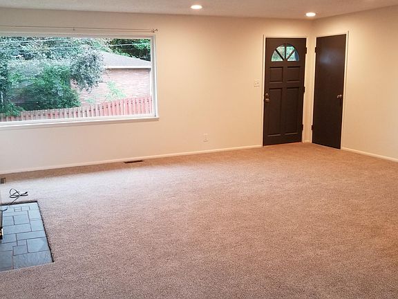 Large living room with fireplace and peek-a-boo view of lake washington