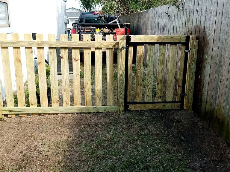 View of the fence enclosure on the left side looking outwards at the gate