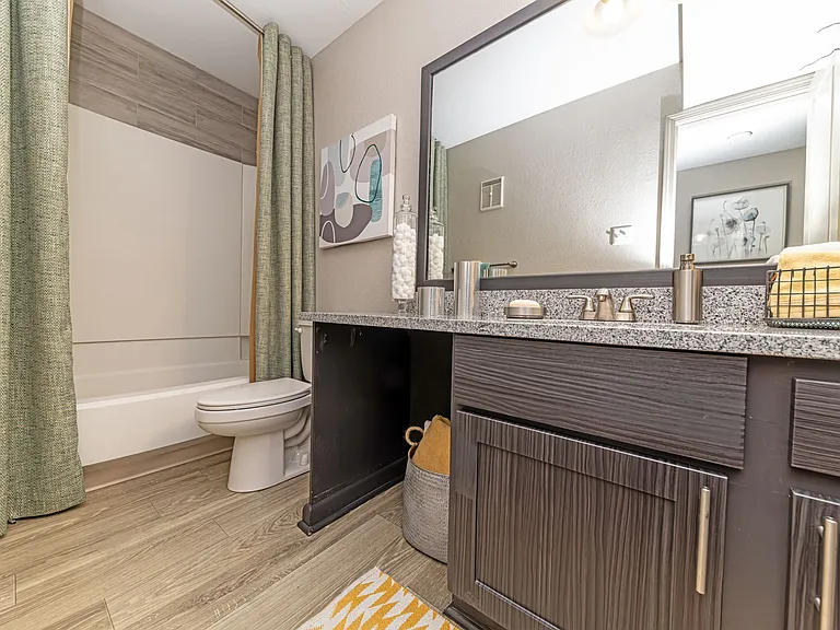 Bright bathroom with granite counters and large mirror