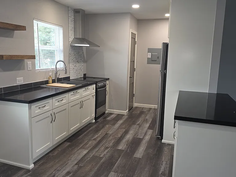 8x10 Partial open concept kitchen with a 5ft Island that has a built in microwave, stainless steel appliances,24in slide in electric stove. walking pantry with shelves.