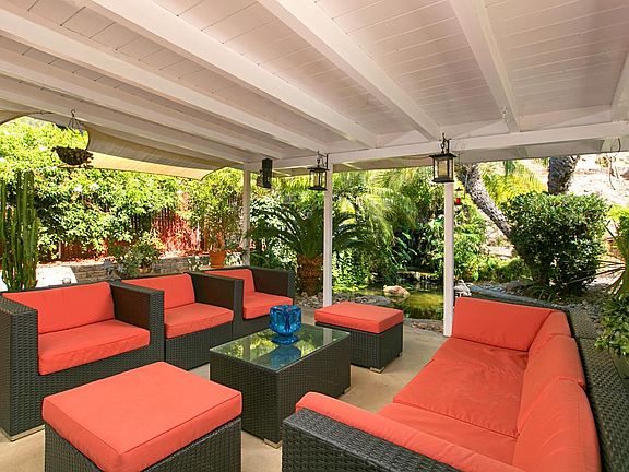 Outdoor covered patio area with koi pond and waterfall