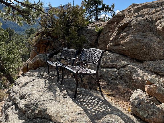 Lookout benches at the top of the rock (small mountain) attached to the house. Views of valley and Longs and Meeker Peeks from here.
