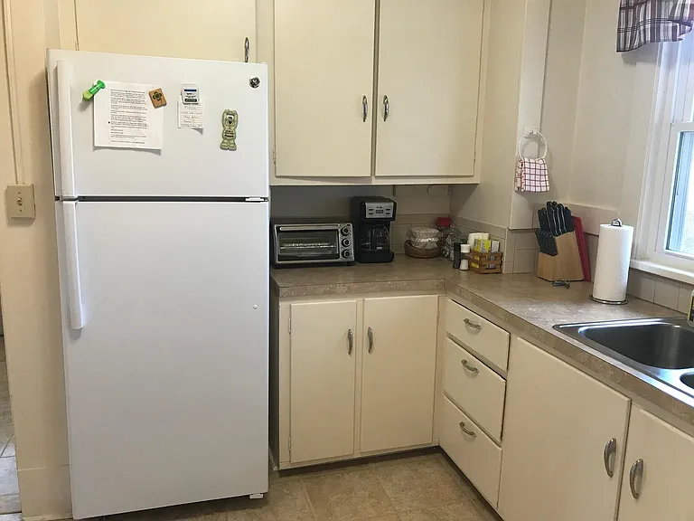 View of refridgerator and cabinets in kitchen.