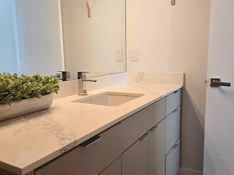 The primary bath with beautiful quartz counters and custom tile flooring