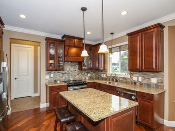 The kitchen shows off the designer cabinet package, Granite counters, back splash, vented hood, Hard wood floors and more!