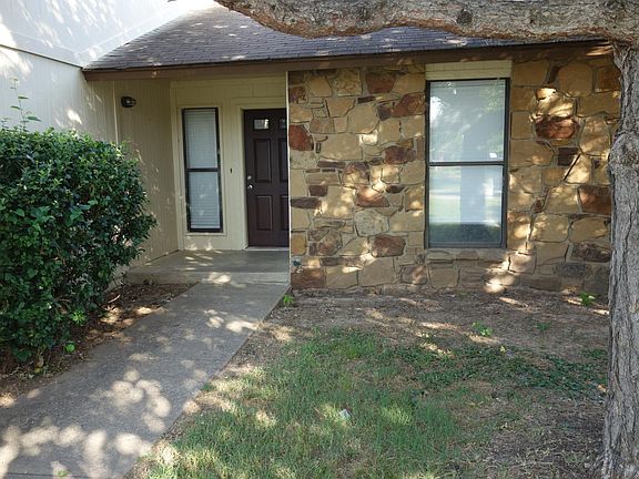 Front door of this home with window to dining area on left and 2nd bedroom window on right
