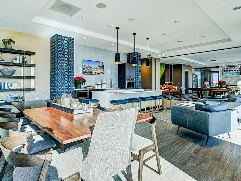Resident lounge area with bar top seating, catering kitchen, lounge seating, entertainment area, and rooftop pool access