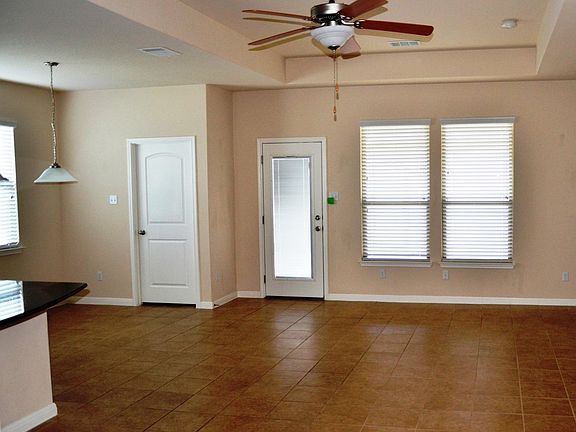 Back half of living room, facing one of the two back doors.