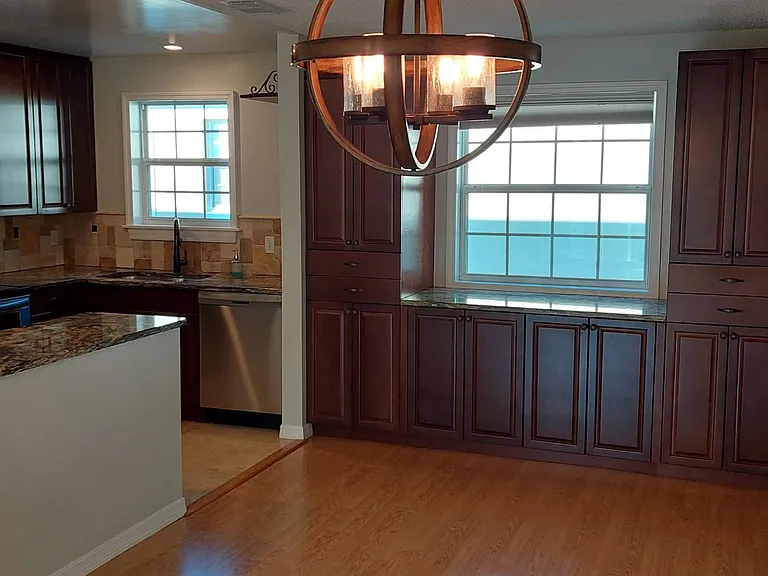 The kitchen and dining space with the front door to the right of the room.