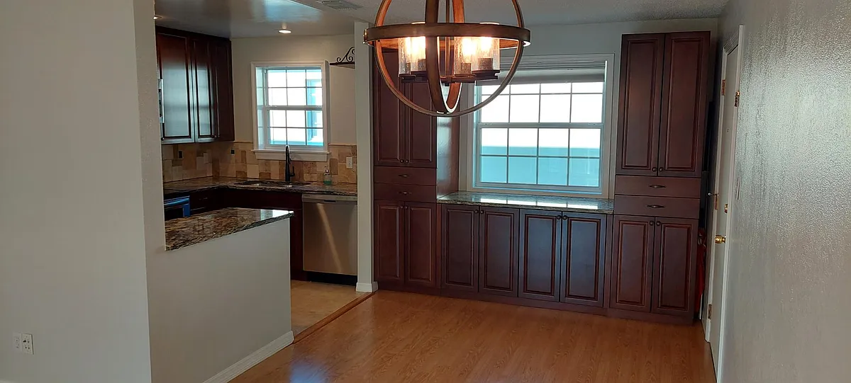 The kitchen and dining space with the front door to the right of the room. - 1500 Gay Rd
