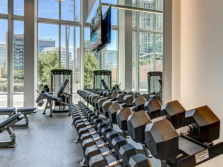 Free Weight Section in Fitness Studio With Mirror Wall and Full Rack of Dumbbells