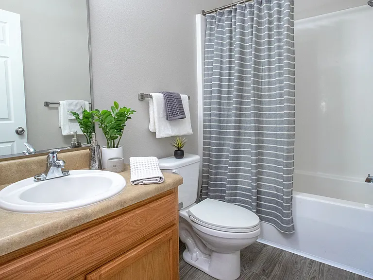 Experience the stylish allure of the guest bathroom, adorned with gracious mirrors, sleek chrome fixtures, and abundant counter space for your convenience.