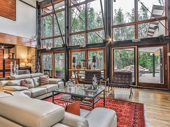 Upon entry, you are greeted by a serene view of the backyard with expansive living space, stone surround fireplace, and redwood cabinets.