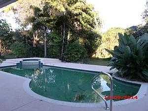 Unscreened pool with lush tropical foliage & large