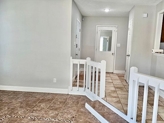 Left side entrance door, staight view garage and side view of sink in living room area