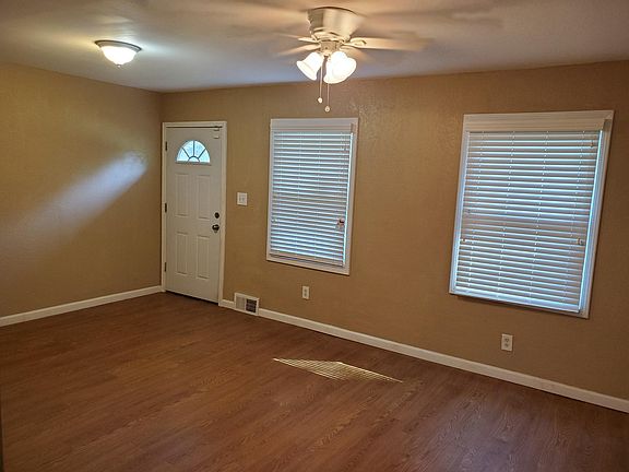 Living room with lots of natural light, custom wood look blinds and easy care flooring.