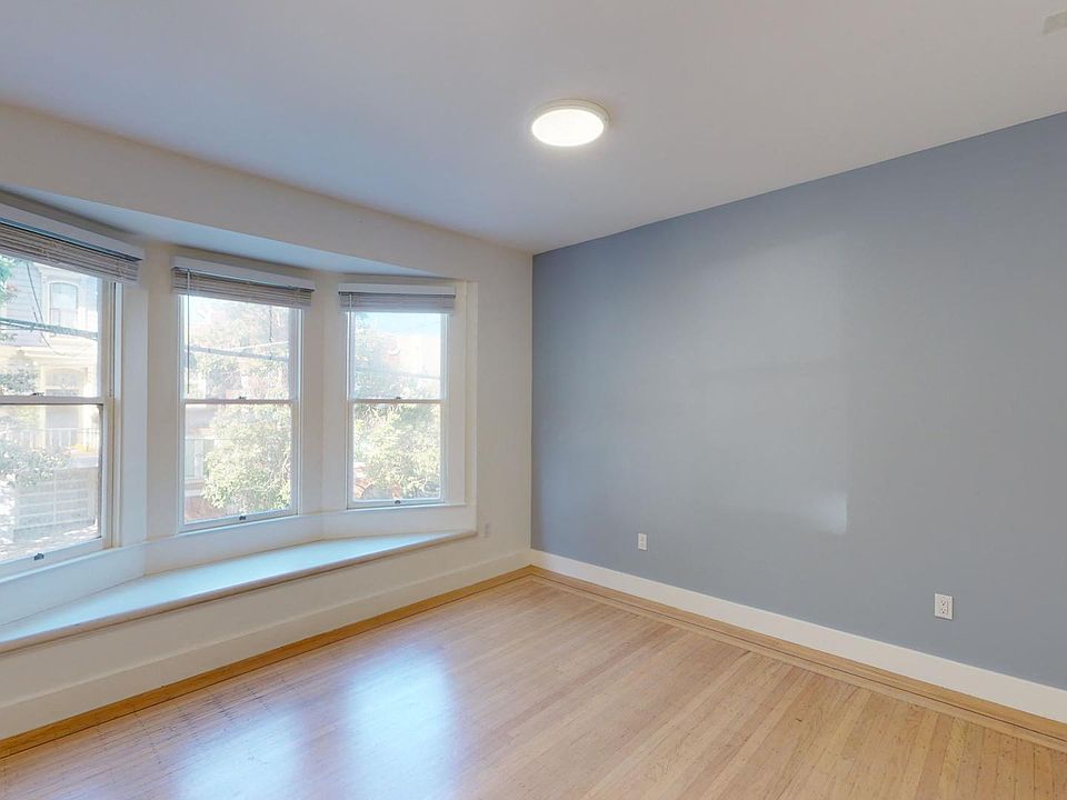 Sunlit living room with a wood-like flooring and a large window