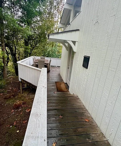 Walkway along left side of home leading to private entrance front door and deck area with Teak patio table and chairs.