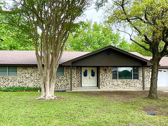 Front view with sprawling shade trees