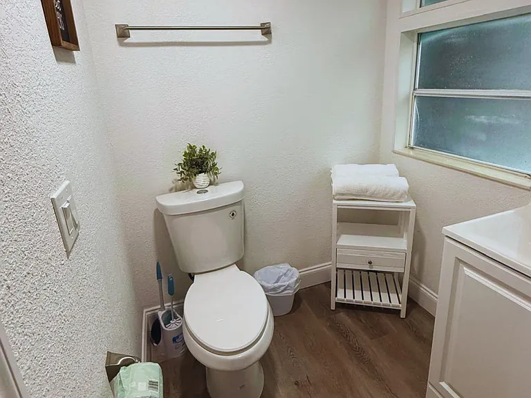 Clean and well-organized space with towel storage, toilet and elegant accents.