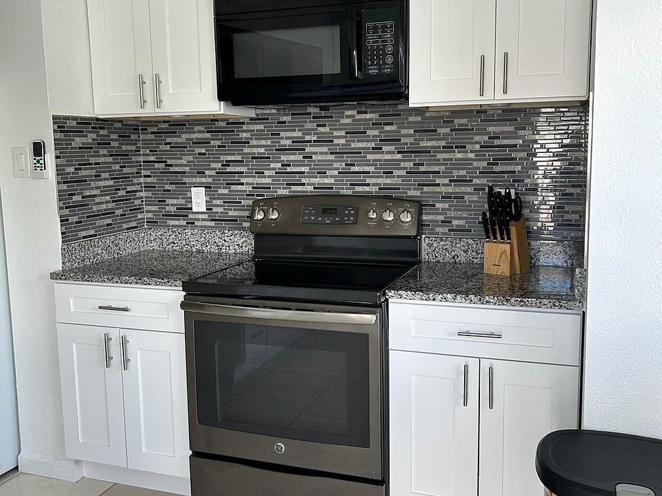 Fully equipped kitchen with stove, oven, microwave, fridge, and ample cabinets.