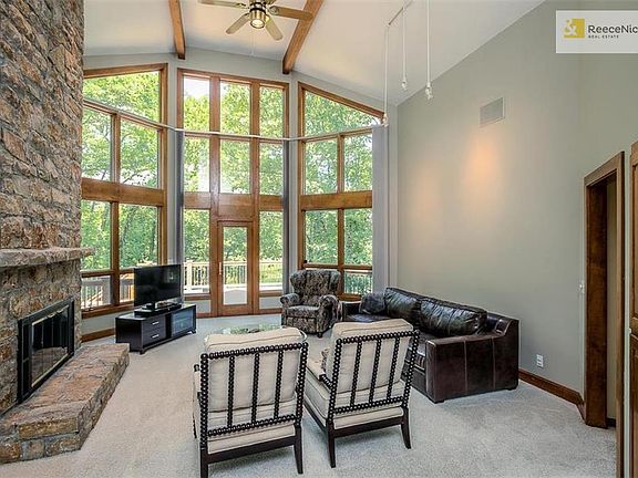 Spacious two story great room with walls of windows of the trees and water views!
