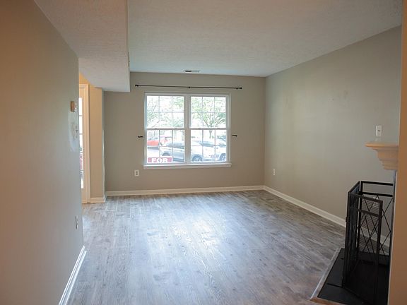 View of the living room from the dining room; front door can be seen on the left at the end.