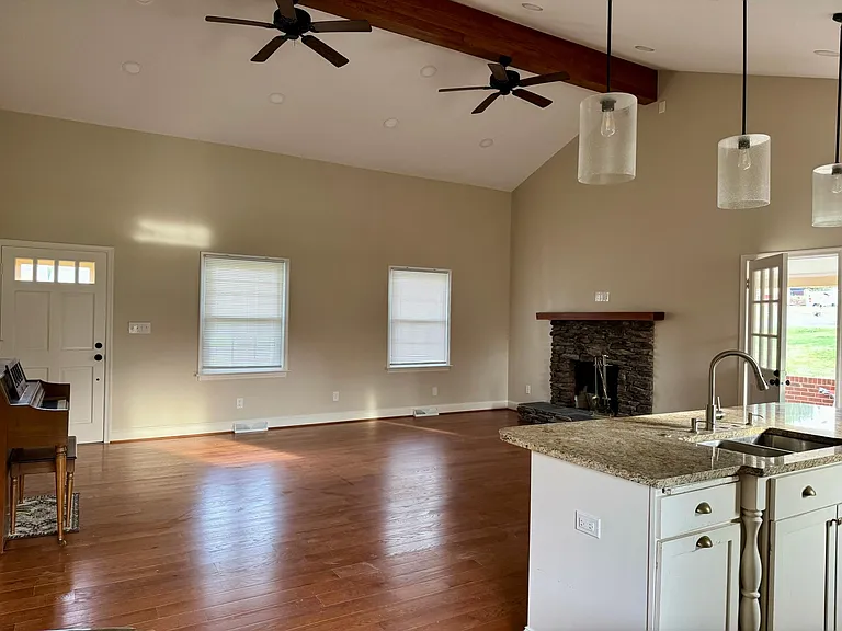 Spacious living room with functioning, wood-burning fireplace.