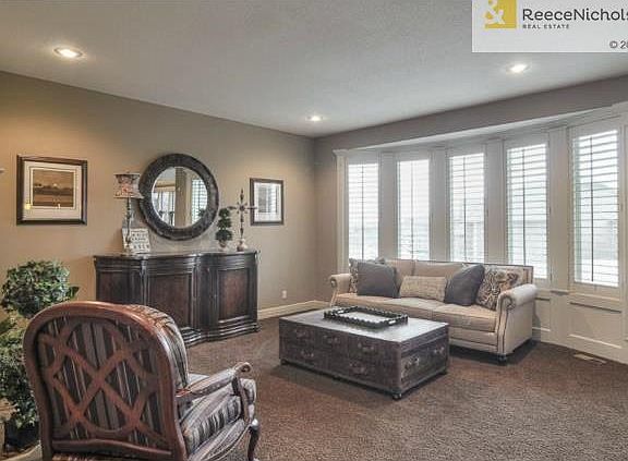 Bright and inviting great room with plantation shutters and see