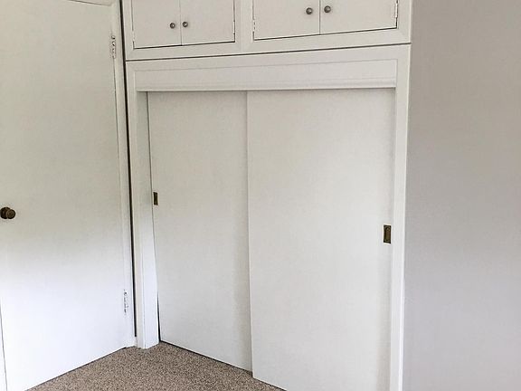 Master bedroom closet with above cabinet storage