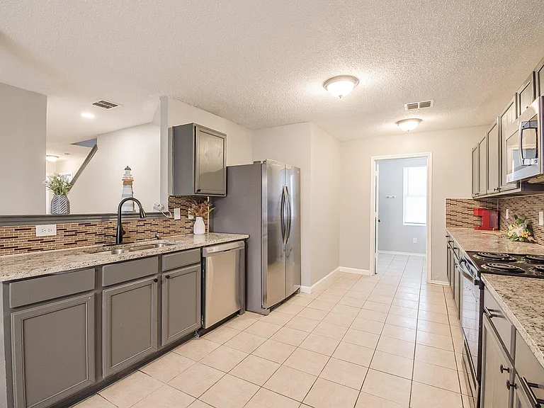 Spacious kitchen with granite-look counters, stainless steel appliances, and plenty of cabinet storage for easy meal prep.