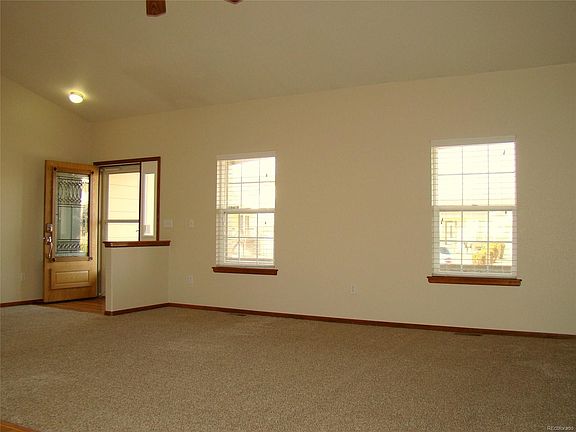 The entry way and living room look out to the covered front porch that runs the full length of the home