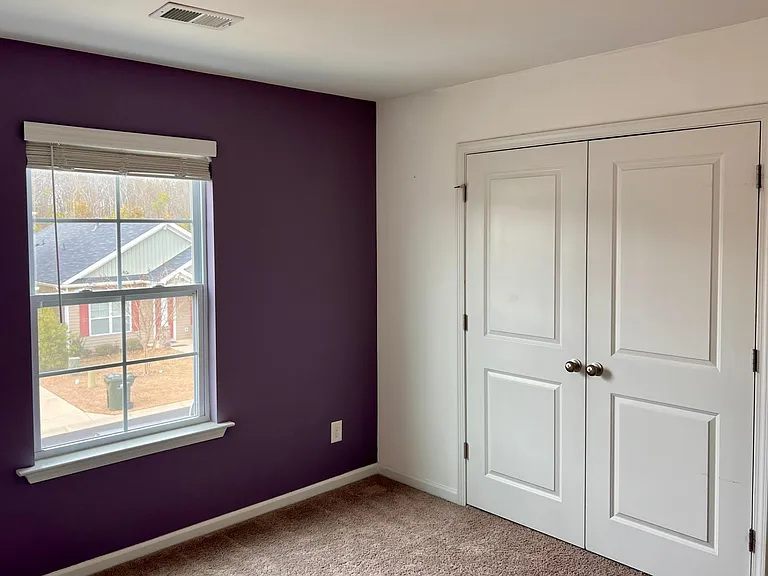 3rd bedroom with closet and accent wall.