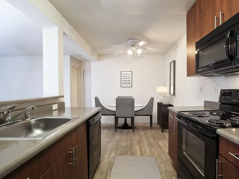 Classic Package kitchen with black appliances, dark grey laminate countertops, cherry cabinetry, and hard surface flooring