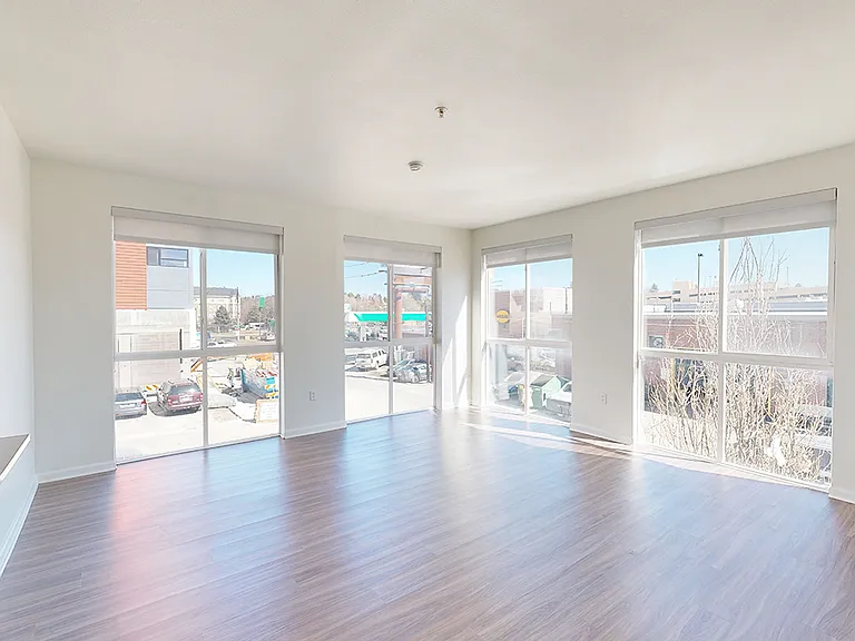 Apartment living room with wood-style flooring and patio or balcony in select homes.