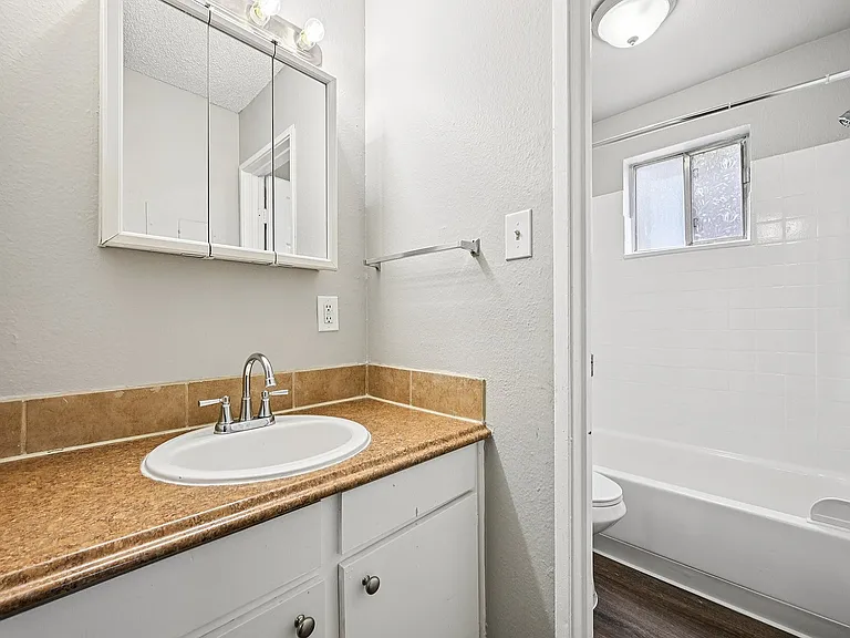 Bathroom featuring a modern sink, elegant mirror, and ample natural light